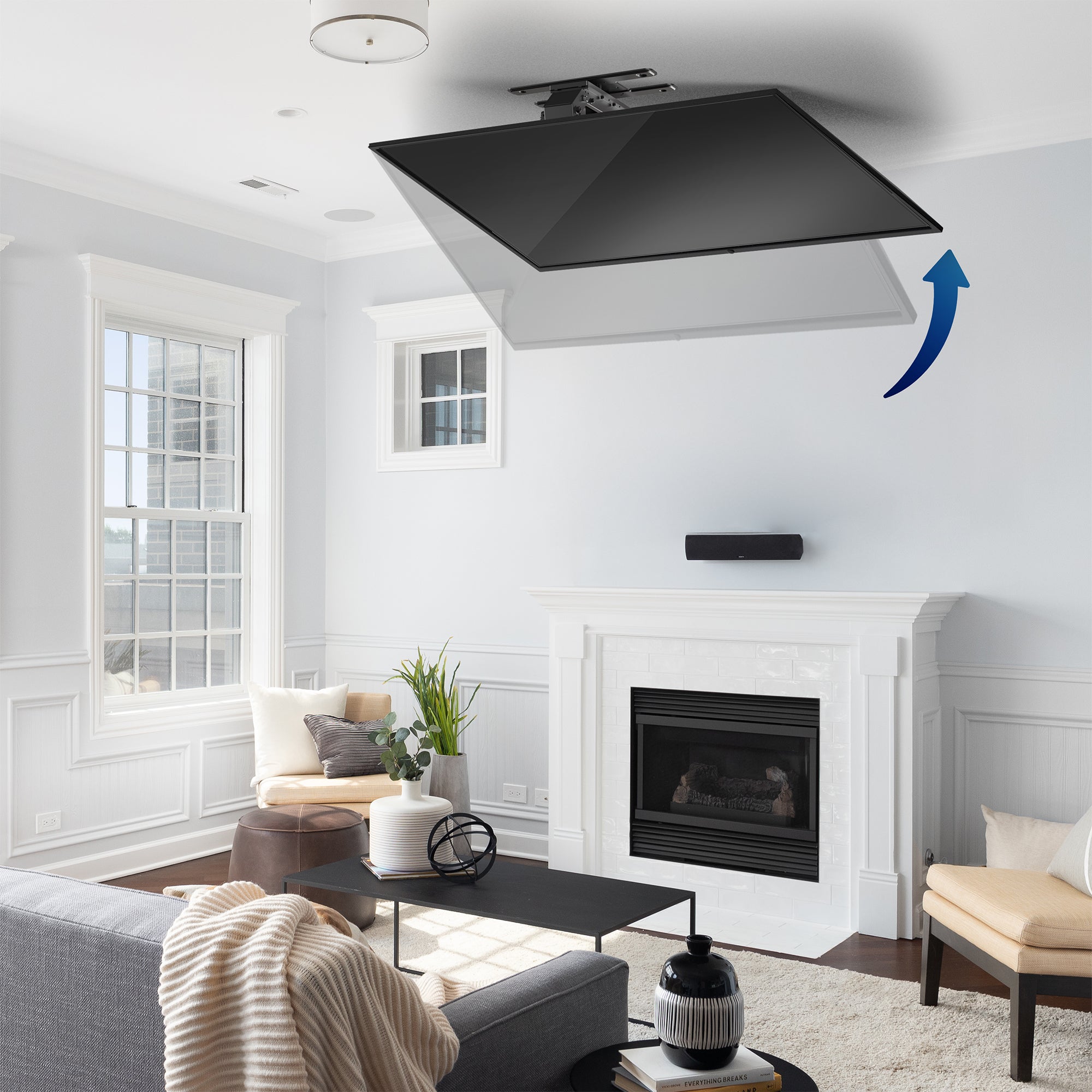 A black electric flip down/swivel ceiling TV mount in a modern living room scene.