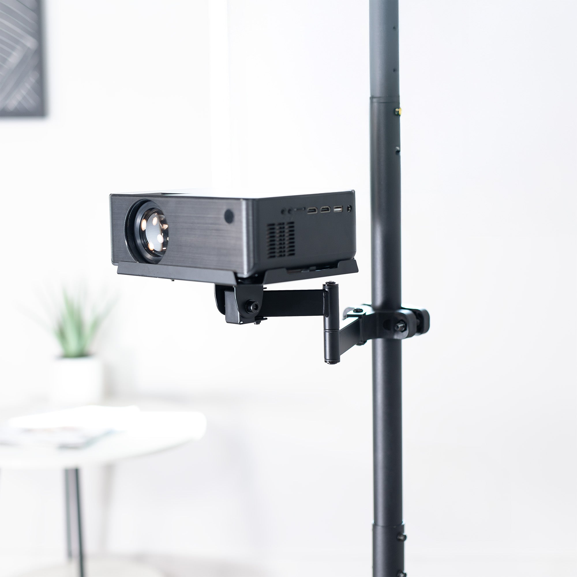 A black pole mount shelf with an articulating arm designed to attach to a pole.