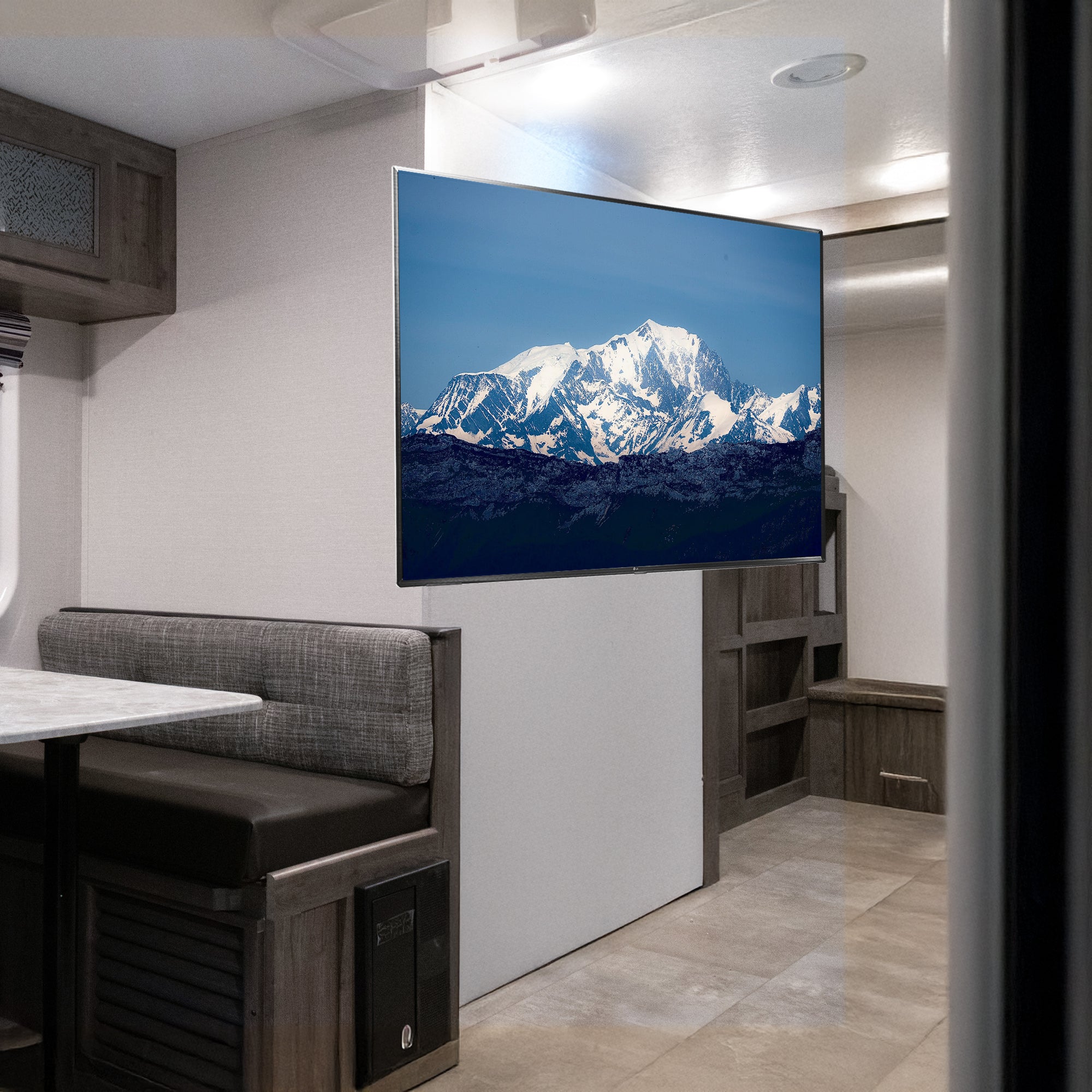 A black locking RV TV mount with articulating arm by VIVO in a camper scene.