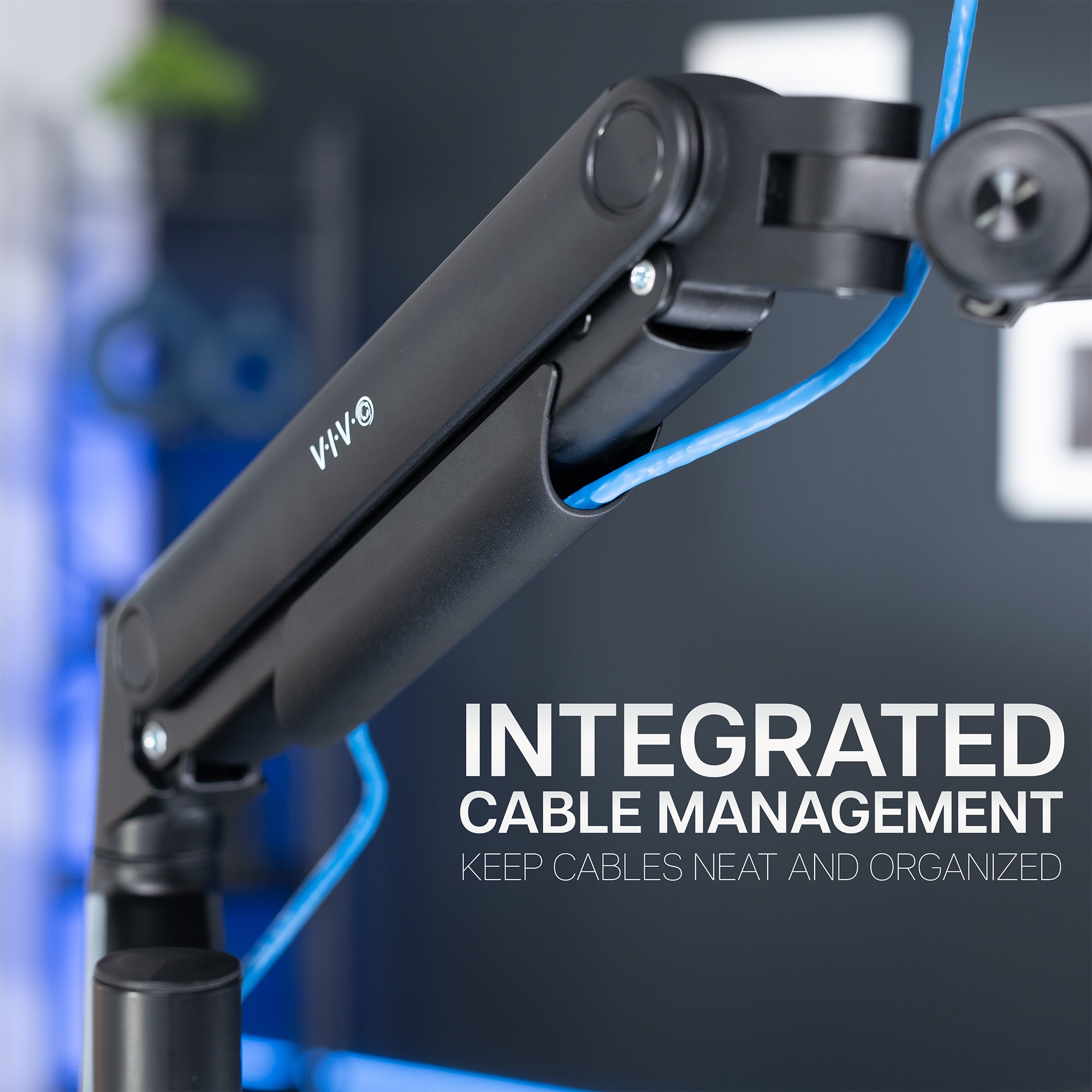 Black adjustable monitor mount arm with an integrated cable management system on a blurred background