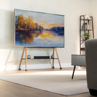 Modern living room with a large TV displaying a nature scene on wooden TV stand, and gray sofa in foreground.