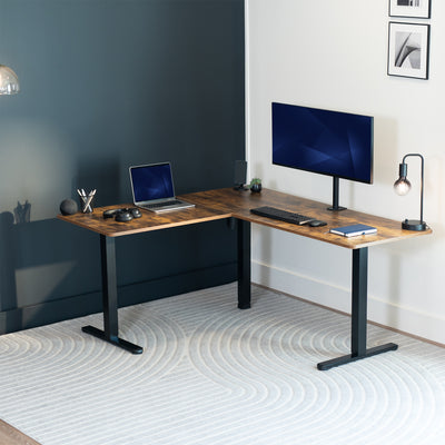 Modern L-shaped desk with computer setup in a room with dark walls and light floor.