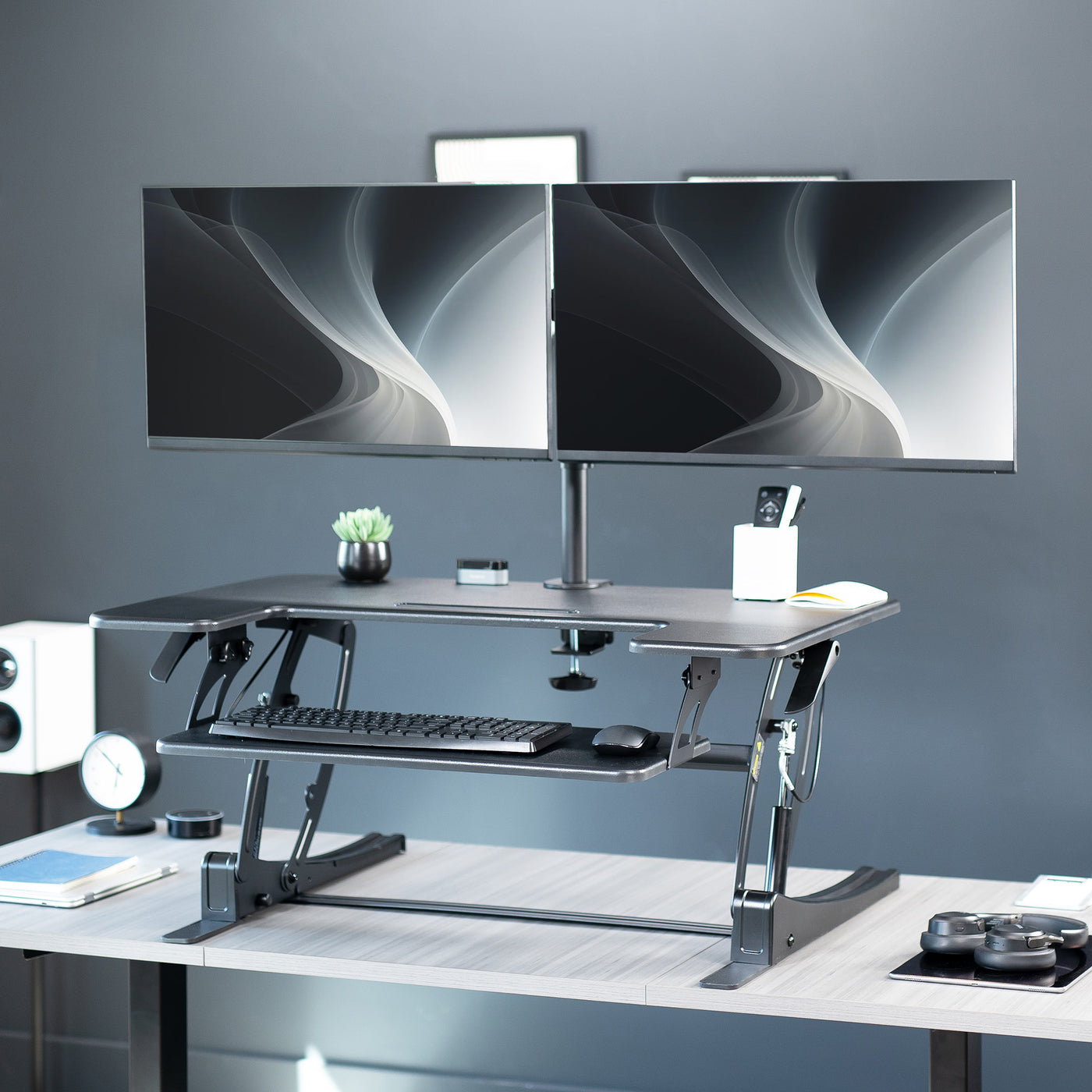 Height adjustable desk riser with articulating dual monitor mount.