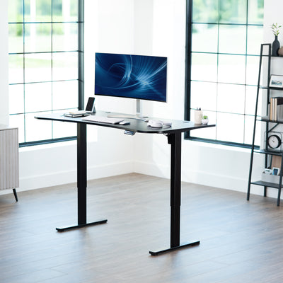 Sit or stand an electric height adjustable desk in office setting.