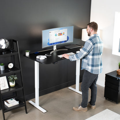 Sit to stand height adjustable electric desk with push button memory controller for ergonomic office workstation.