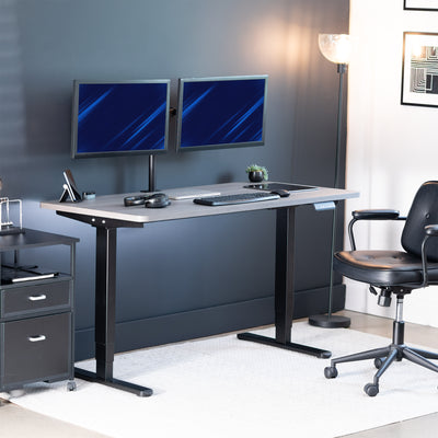 Modern office setup with a standing desk, computer monitors, and chair.