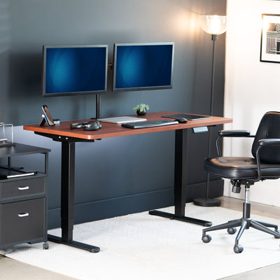Modern office setup with a standing desk, dual monitors, and a chair.