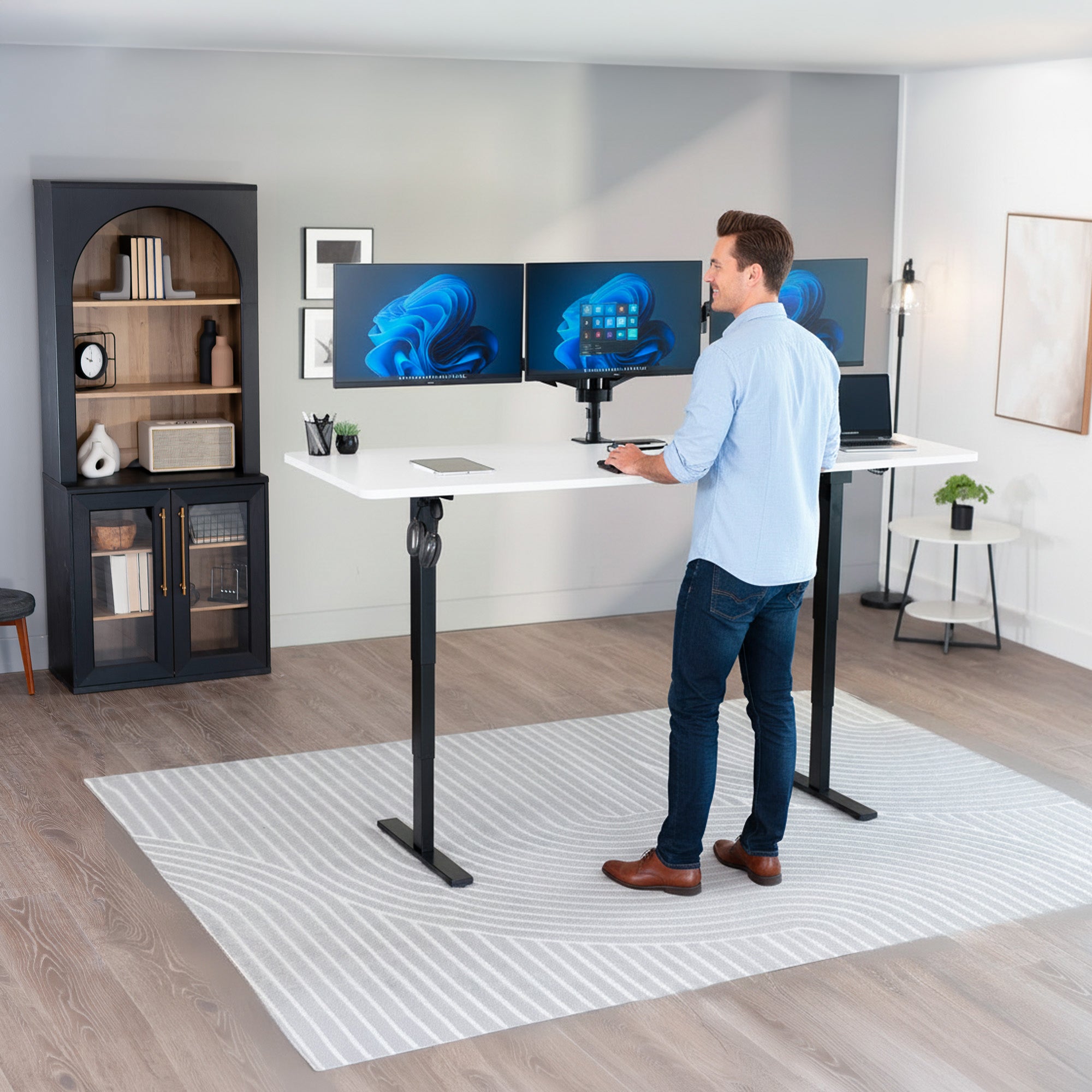 Man standing at the 2E Series - 83" x 30" Electric Desk with Touch Screen Memory Controller