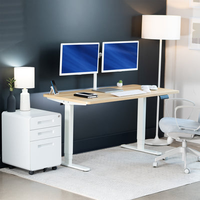 Modern office setup with a standing desk, computer monitors, and office chair.