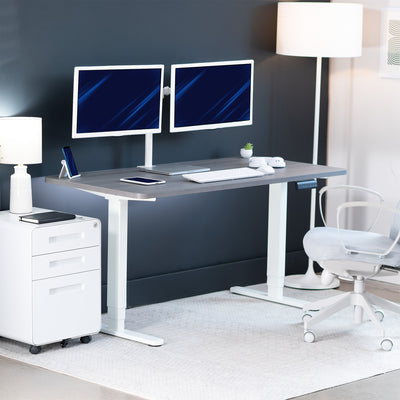 Modern office setup with a standing desk, computer monitors, and office chair.