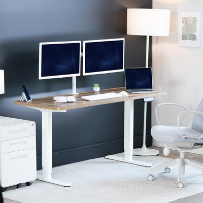 Modern office setup with a standing desk, computer monitors, and a chair.