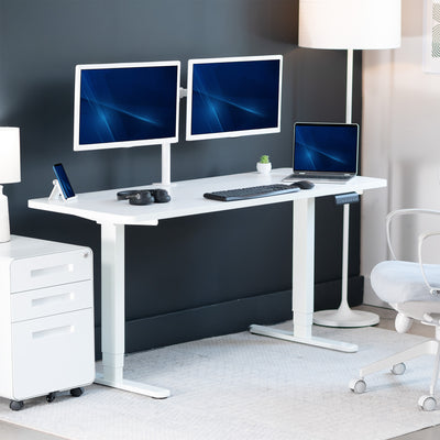 Modern office setup with a white desk, two monitors, a laptop, and office chair.