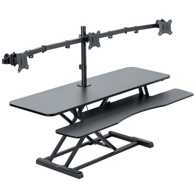 Spacious height adjustable desk riser with articulating triple monitor mount.
