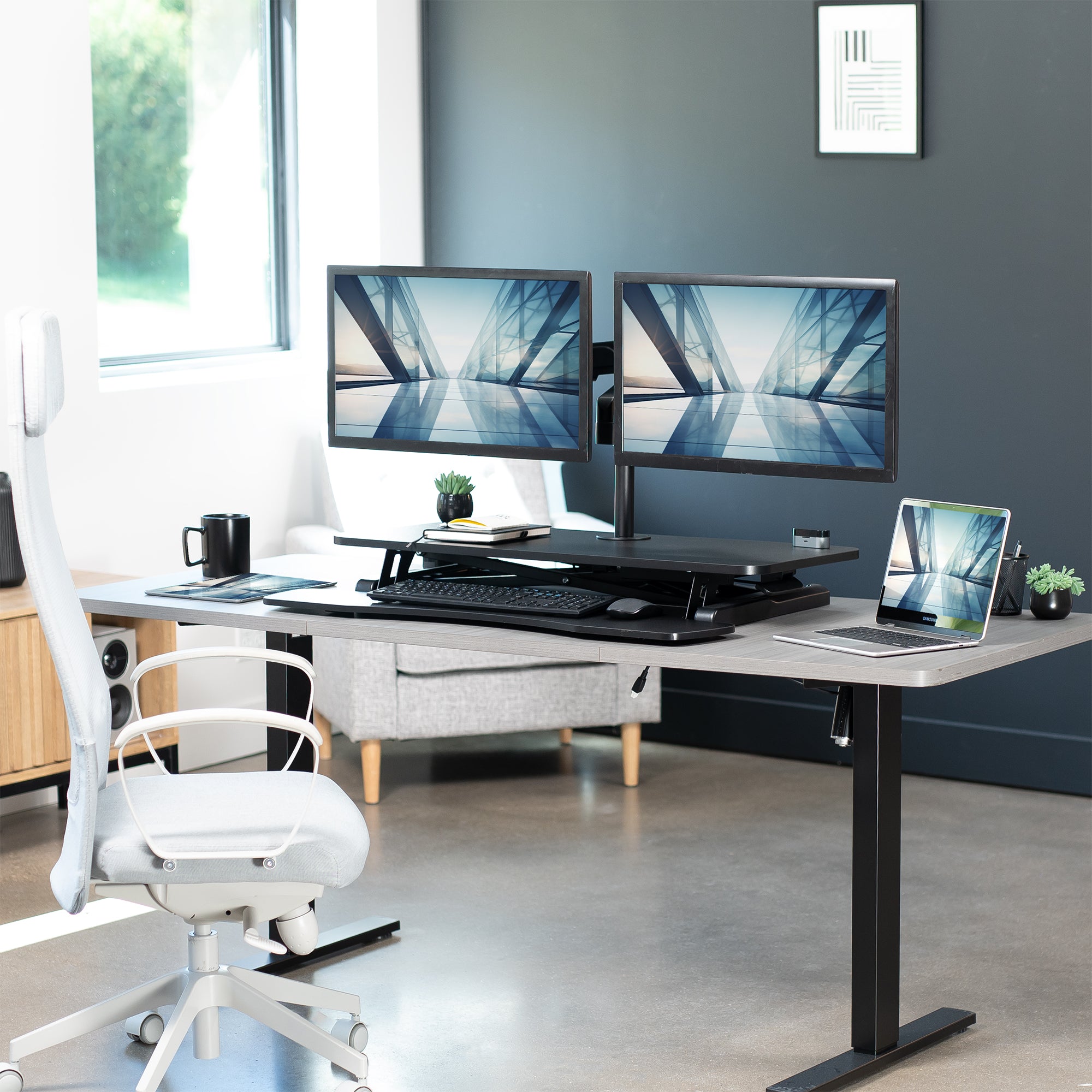 36 inch height adjustable desk riser with articulating pneumatic dual monitor mount.