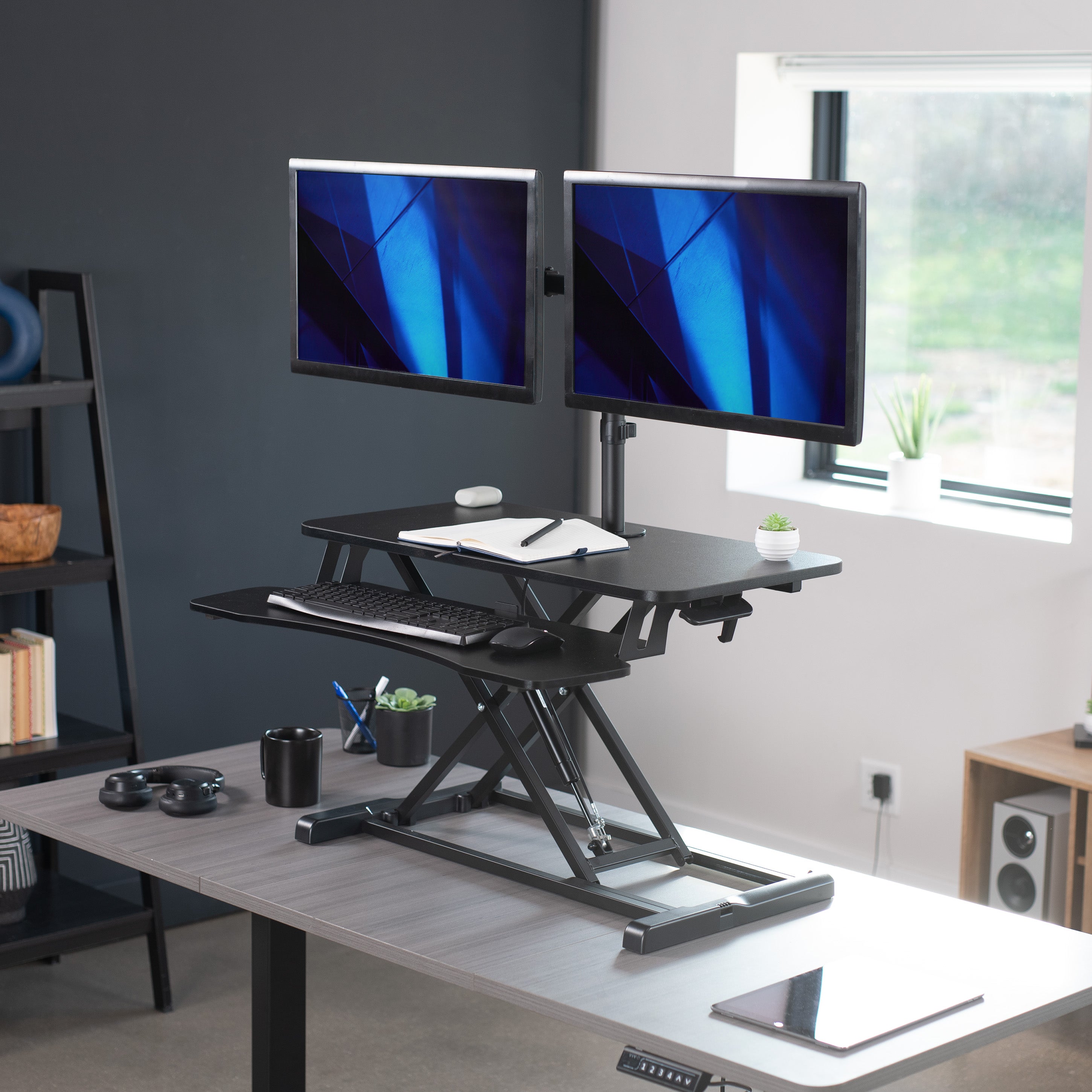 Sturdy height adjustable desk converter with articulating dual monitor mount.