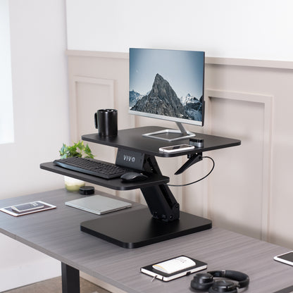 Sit stand desk converter sits on top of current desk and raises and lowers for a comfortable viewing and typing experience.