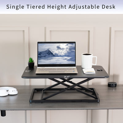 Dimensions of a single-tier height adjustable desk riser providing space for laptop, mug, book, and decorations.