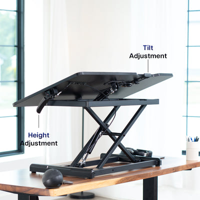 Adjustable standing desk with height and tilt adjustment labels in a home office setting.