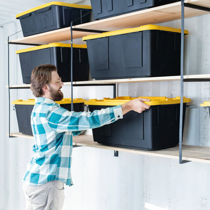 Man organizing storage bins on shelves in a garage setting