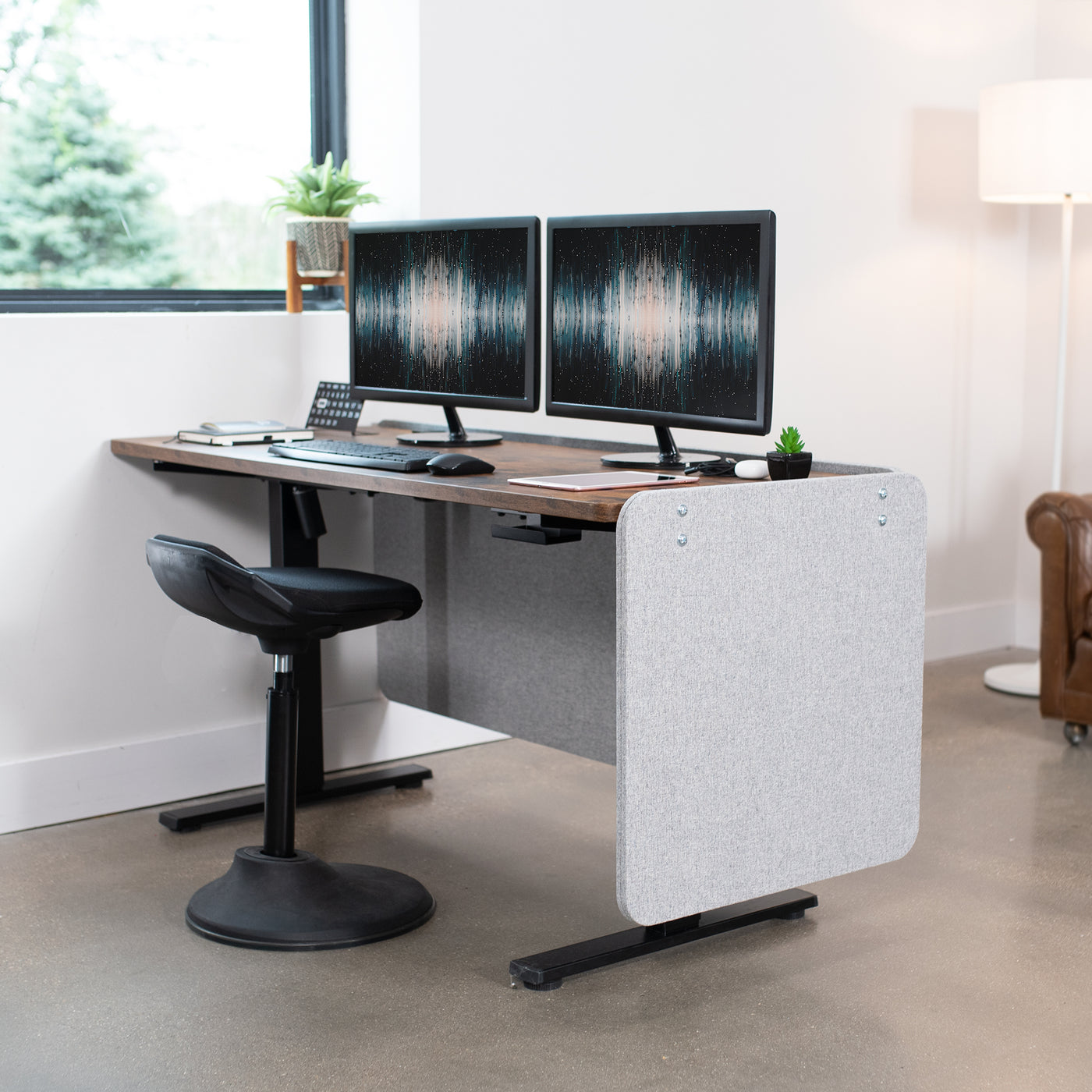 Clamp-on desk privacy panel for office workspace.