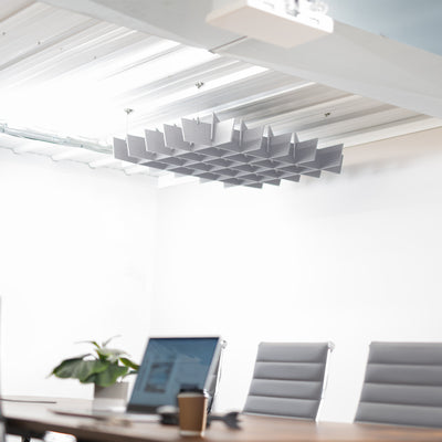 A light gray acoustic dual-layer ceiling waffle panel with a geometric pattern, mounted on a ceiling in a conference room.