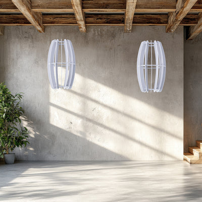 A large oval-shaped acoustic ceiling sound absorber in a light gray color in a rustic studio scene. 
