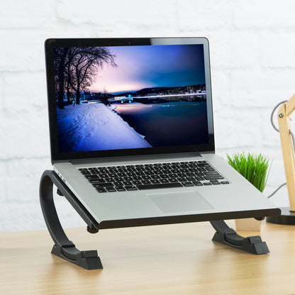 A desktop laptop stand with a plant, lamp, and other office supplies.