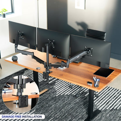 Wooden office desk with multiple monitor stands and a chair in an office setting.