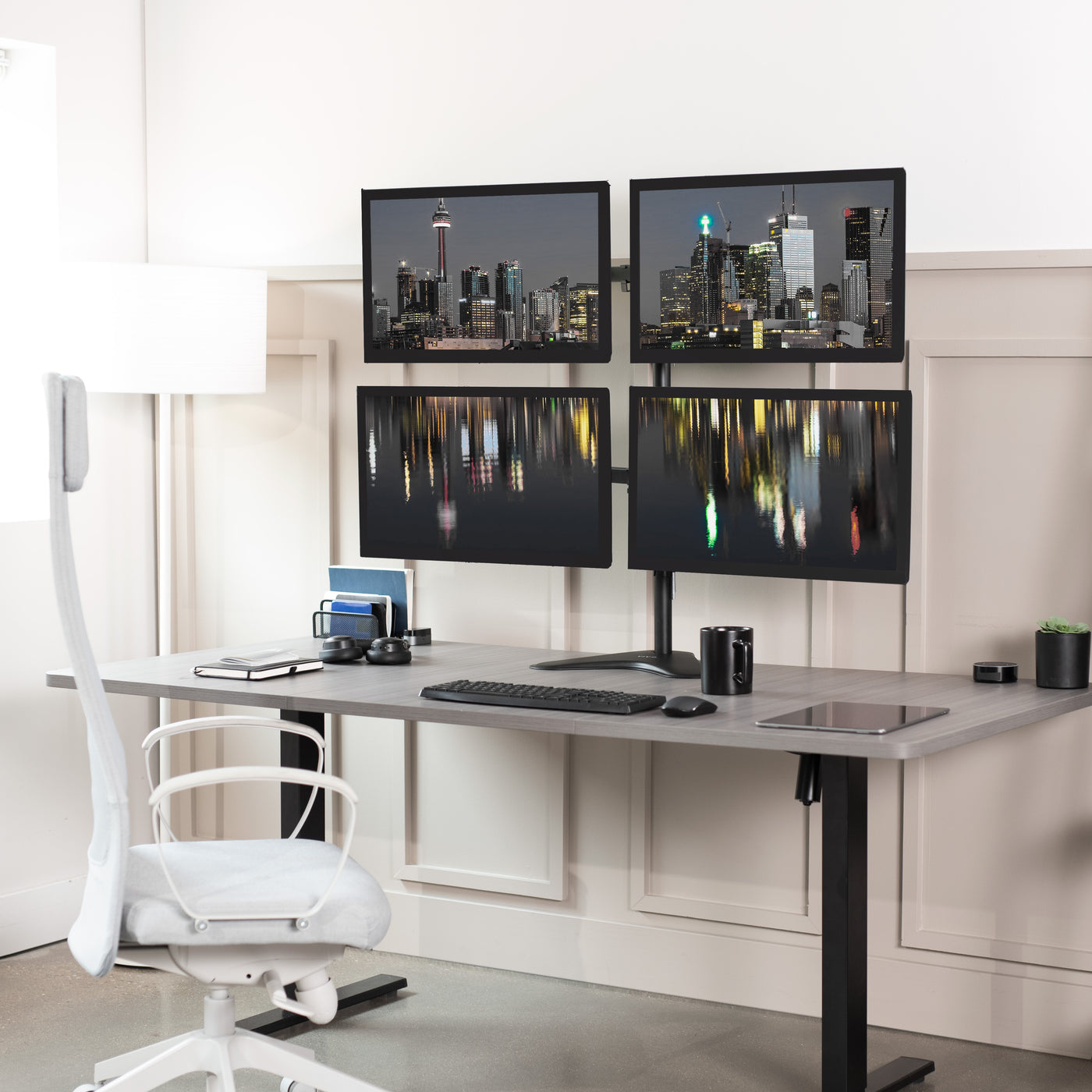 Quad Monitor Desk Stand holds 4 screens for work efficiency at your office desk. Features a freestanding base.