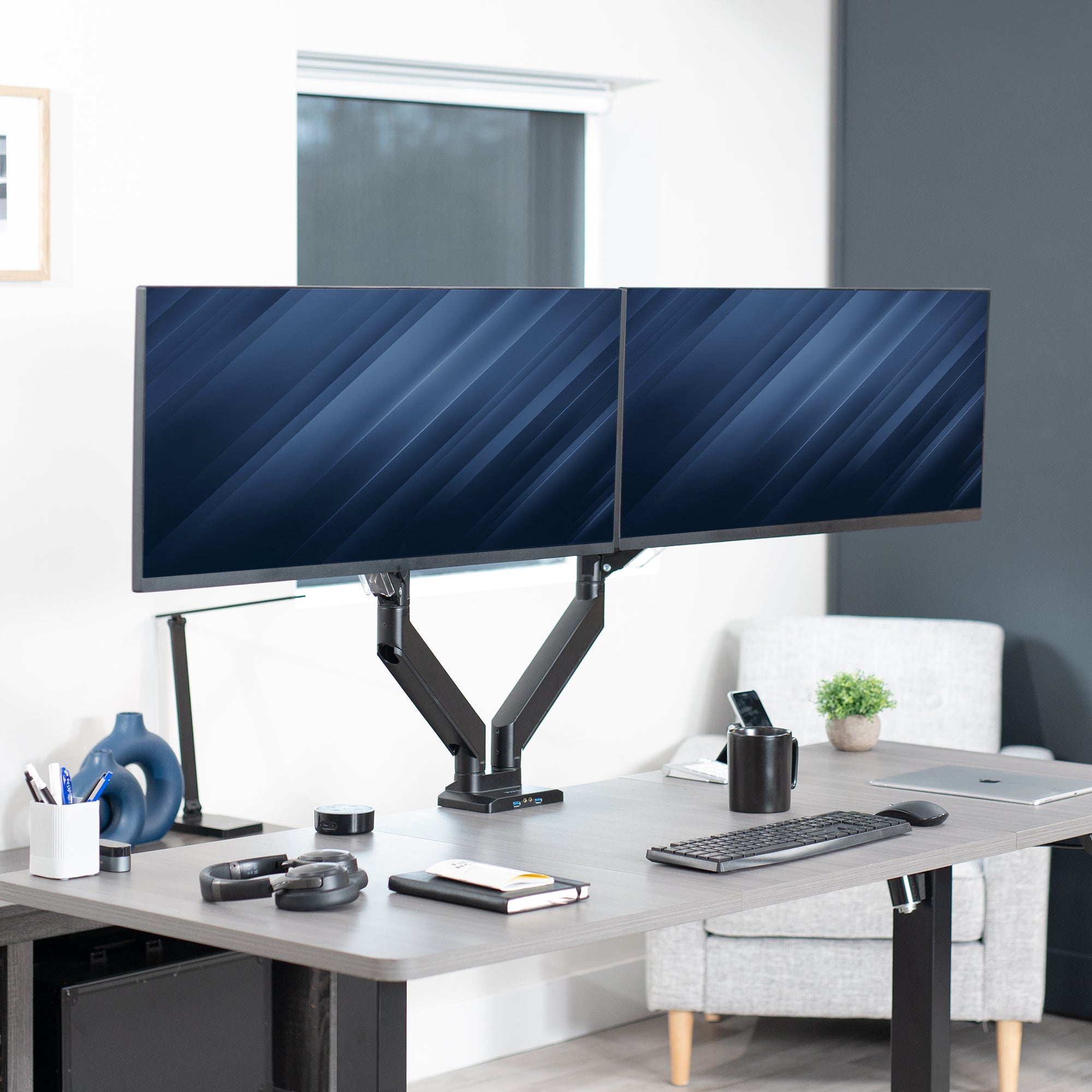 Adjustable pneumatic dual monitor desk mount with USB ports for ultrawide monitors.