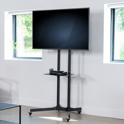 Mobile TV cart displays large screen on rolling stand for ergonomic viewing.