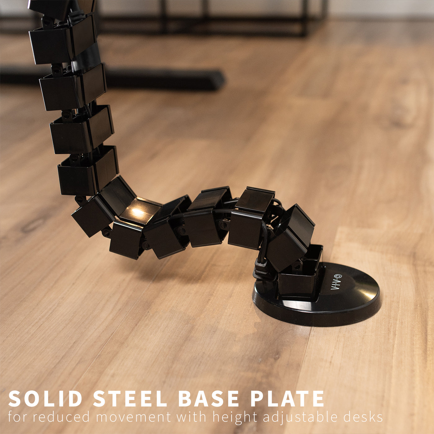 Clamp-on vertebrae cable management for desk with sturdy steel base.