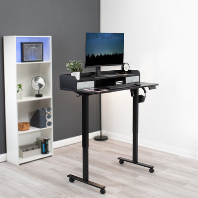 Sit to stand height-adjustable office workstation desk on wheels with a sturdy frame.