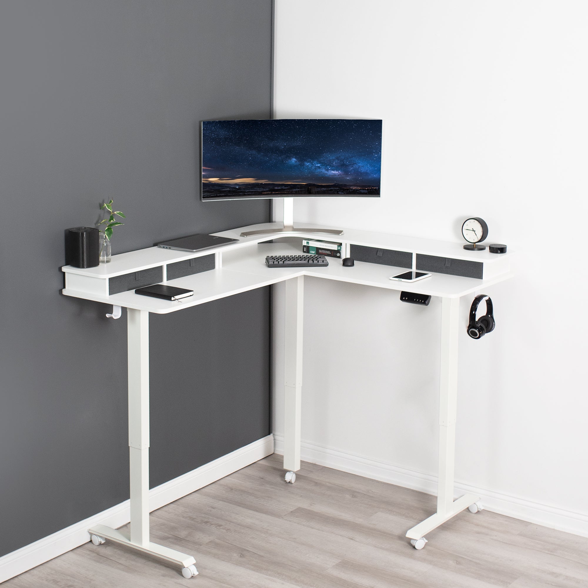 Dual tier height adjustable electric corner desk with storage drawers and wheels.