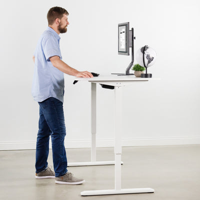 Man wroking at ergonomic sit-to-stand active workstation from VIVO.