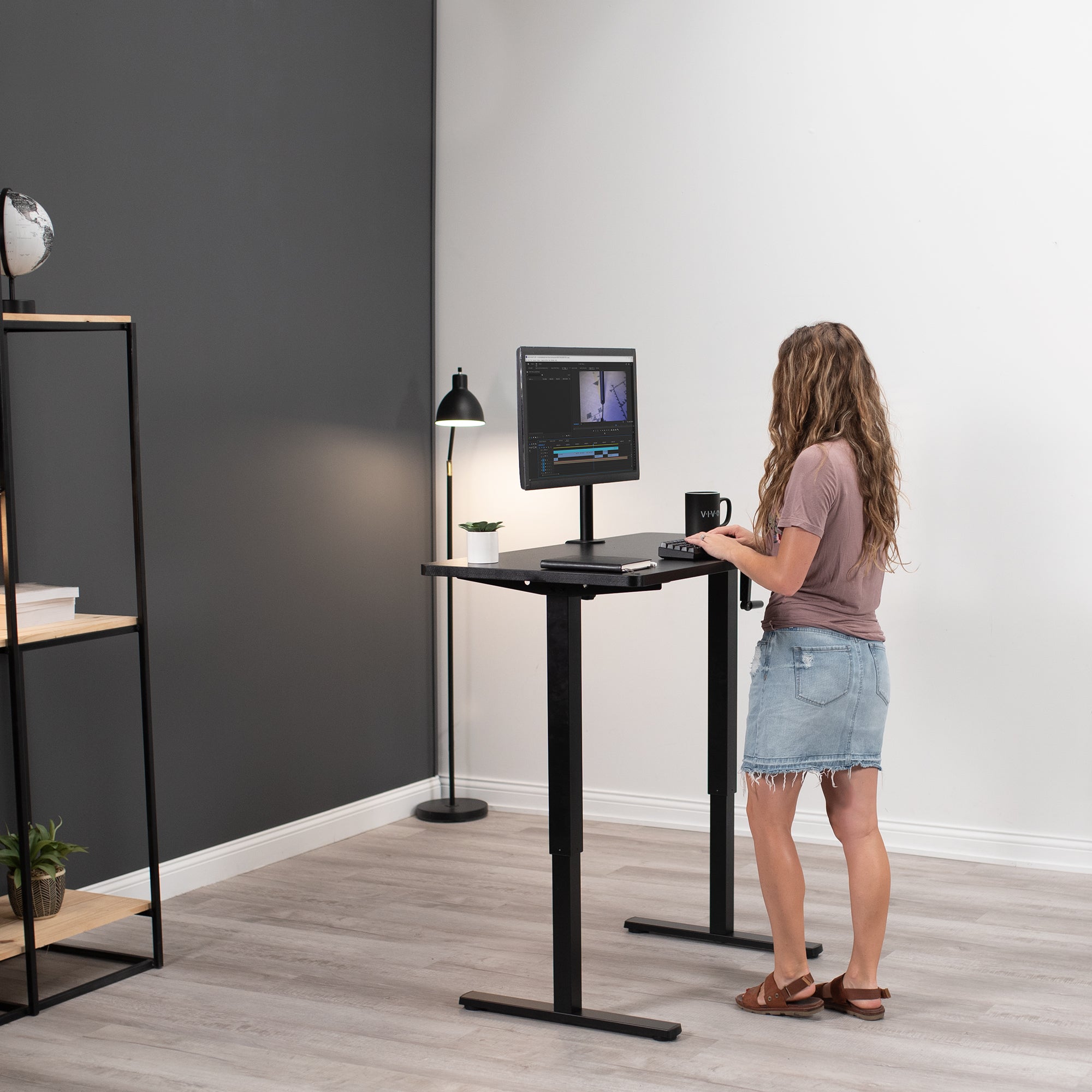 Woman working at a standing height adjustable desk.