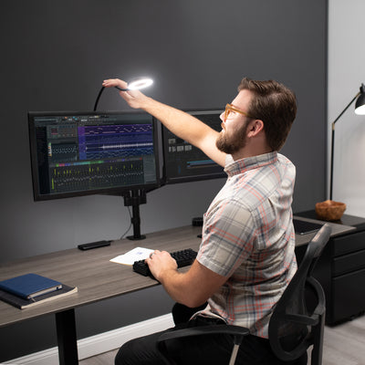 A man in a studio office space utilizing an LED ring light.