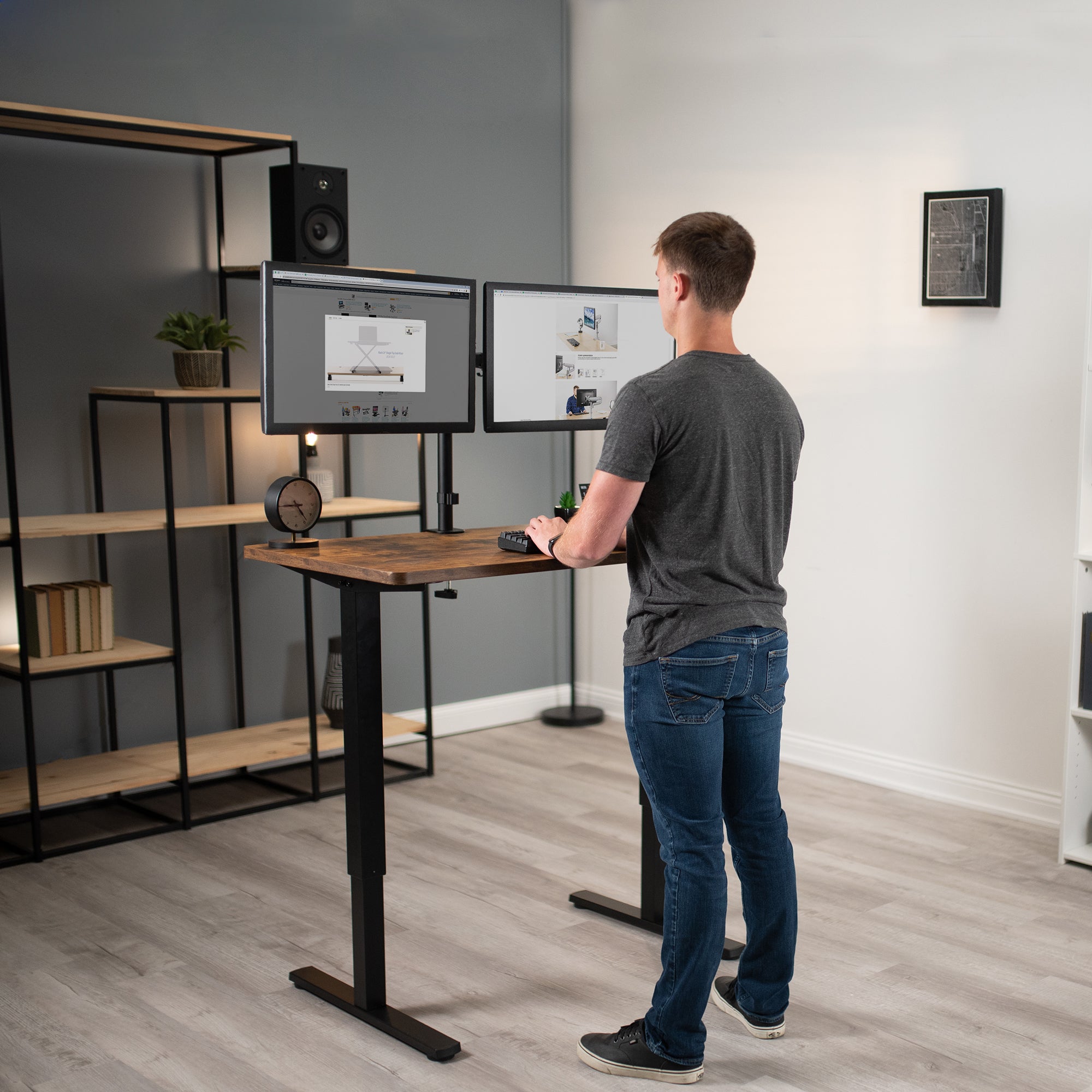  A man working at a manual height adjustable desk with a solid steel desk frame.