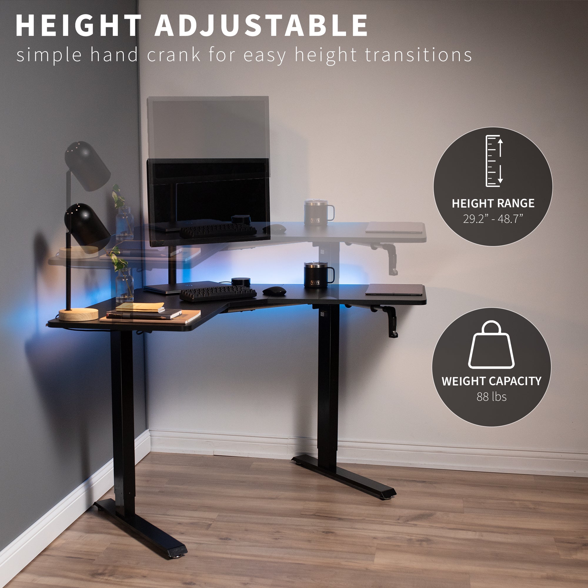 Heavy-duty manual hand crank adjustable height corner desk workstation with large height range.