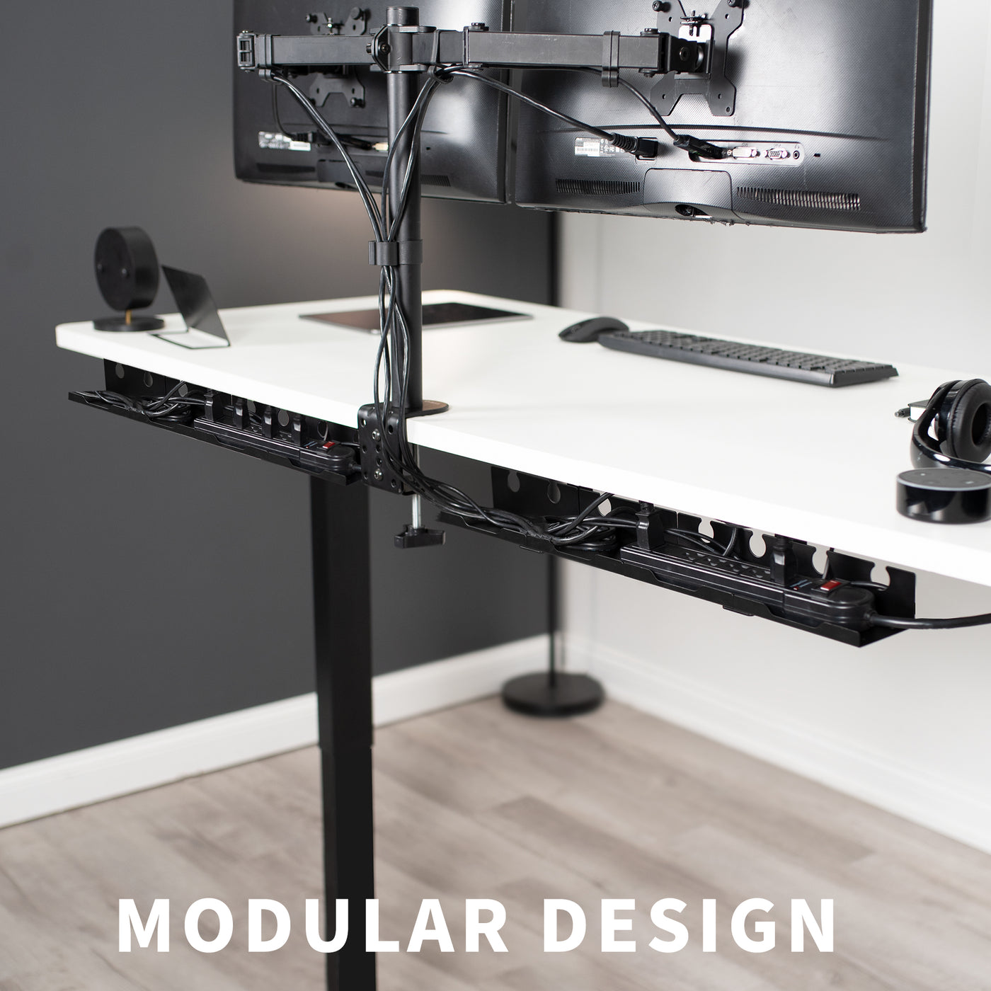 Modular cable management design of two under-desk cable management trays splitting cords and power strips.