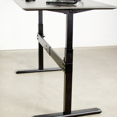Black support clamp on bar with black frame desk.