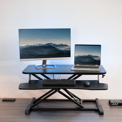 Half extended desk converter ergonomic front view of a workspace.
