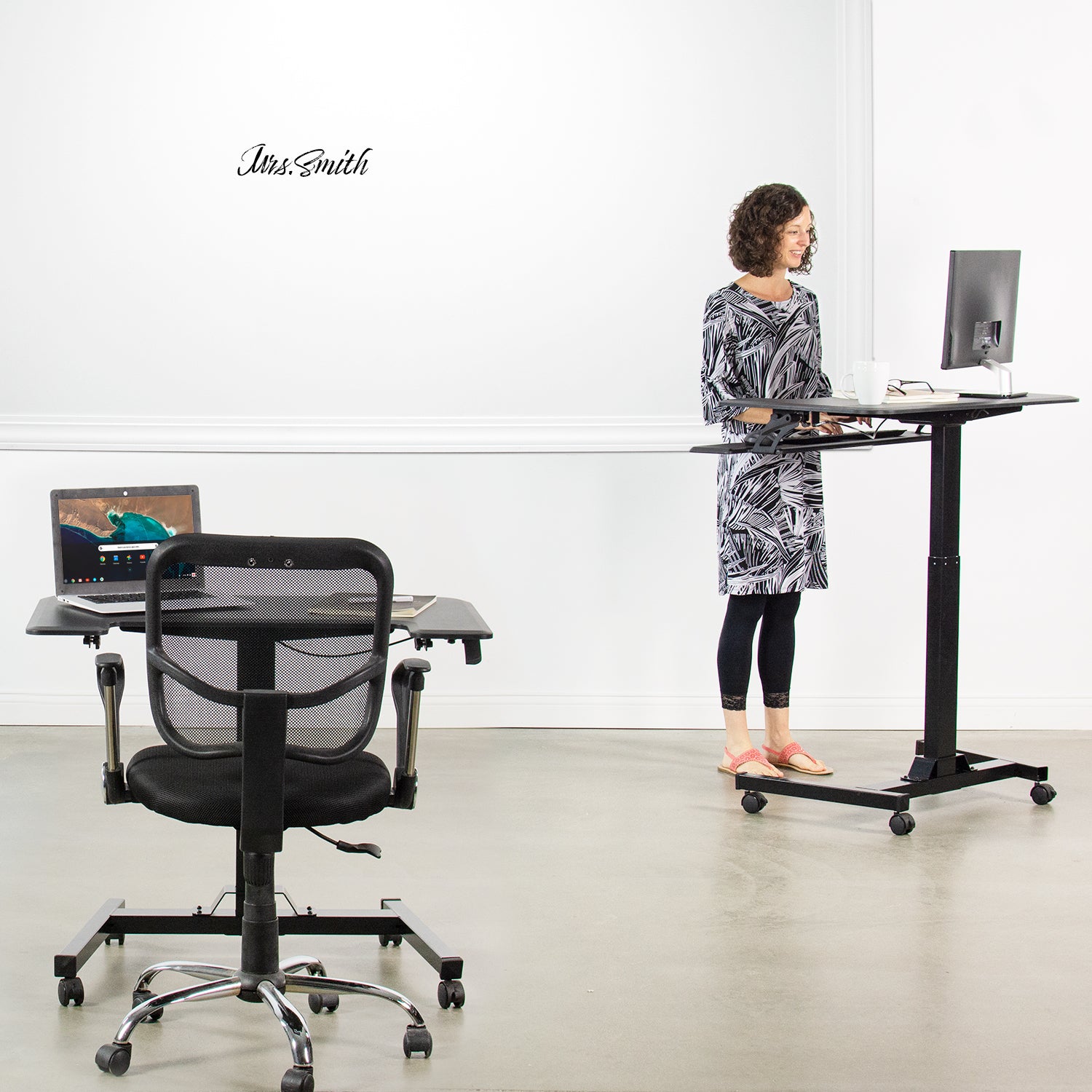 A teacher at the front of the room lecturing from a compact podium desk.