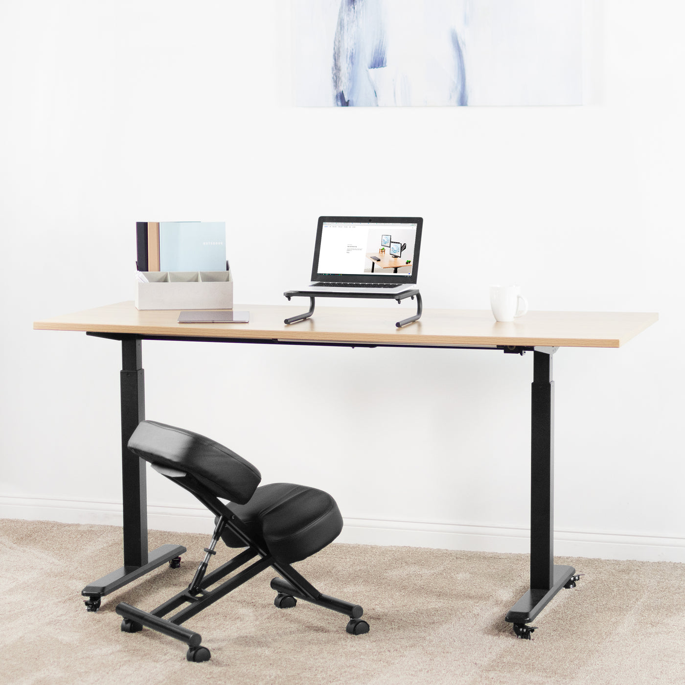 Still action home office space with a sit-to-stand desk, kneeling chair, and laptop riser.