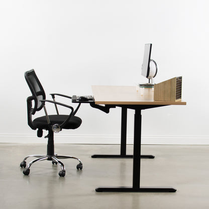 Chair pulled up under the desk keyboard mount.