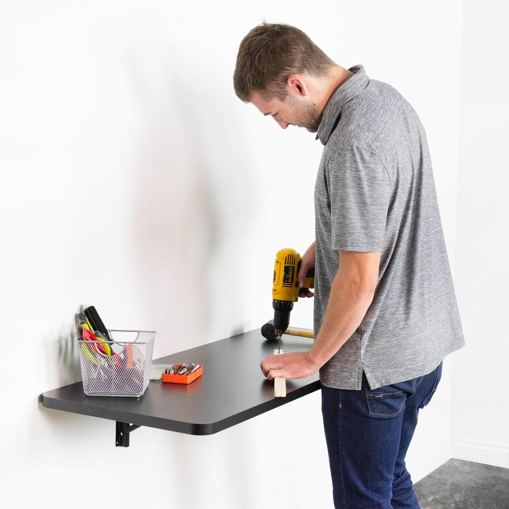 Heavy duty wall-mounted extending shelf being used as a workbench for drilling and woodworking.