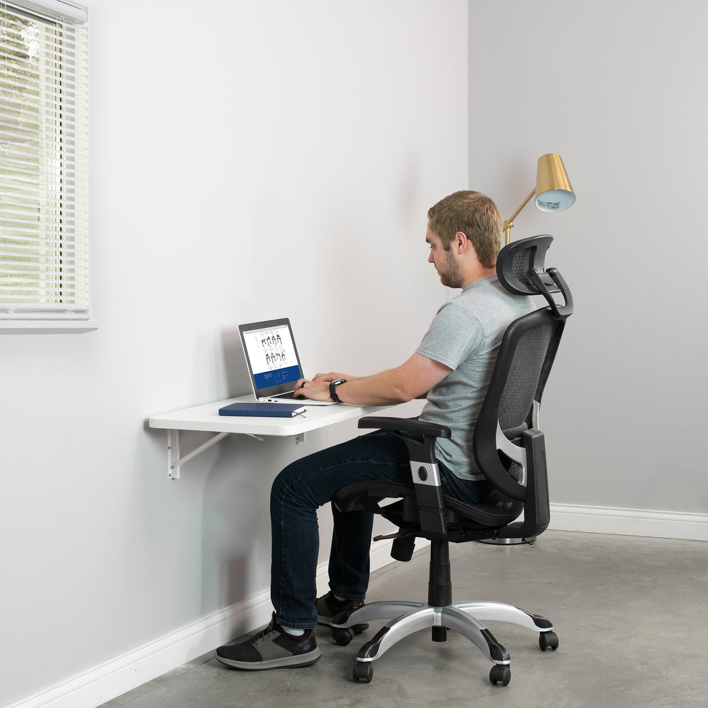 Small office space with a folding shelf being used as a desk.