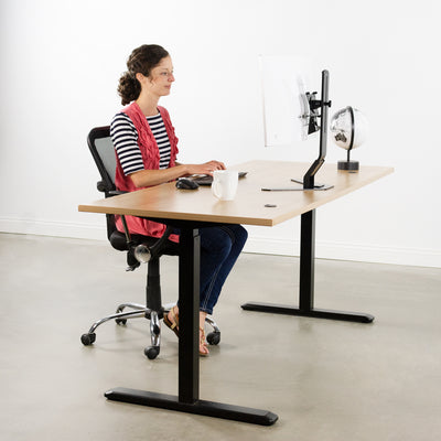 A woman working at a large office desk with a Samsung series CF591 attached to a mount through a specially designed bracket.