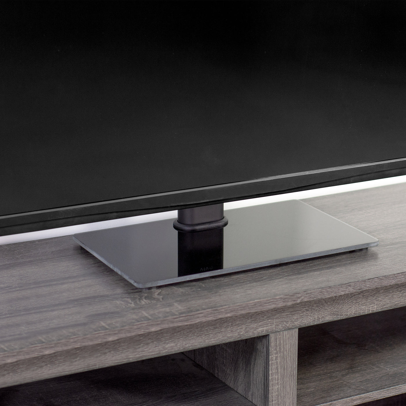 Heavy-duty tabletop TV stand with tempered glass base.
