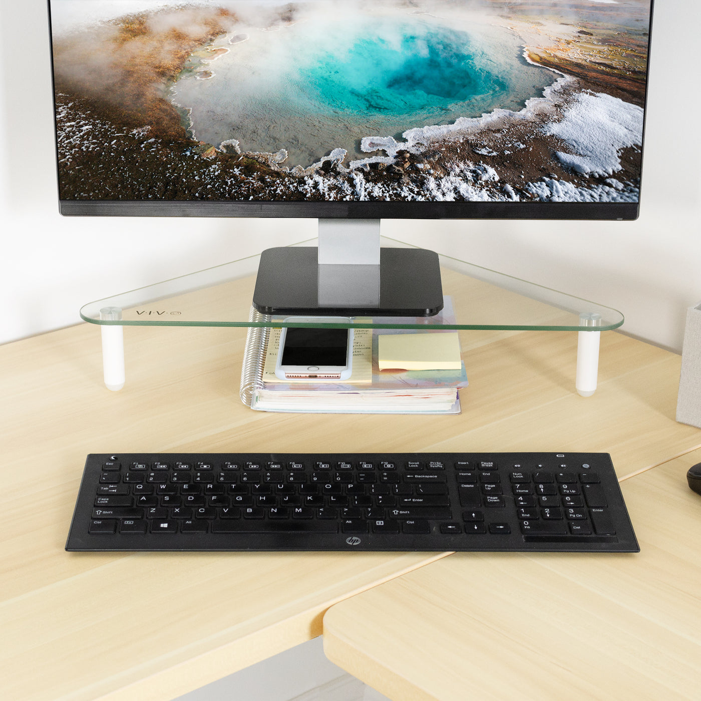 Triangle glass tabletop monitor riser for comfortable viewing.